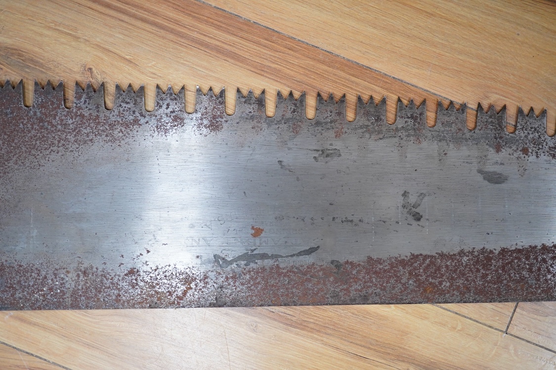 Three large Henry Disston and Sons, Philadelphia, U.S.A. early 20th century hand saws, the largest with a 5’ blade, the makers name still clear on two of the blades, all with similar style wood handles